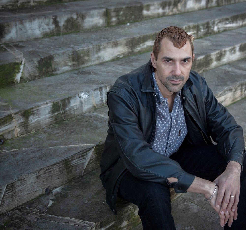 Portrait de Jérémie Nicolas, assis sur des marches 