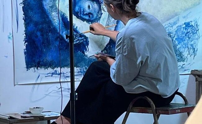 Photographie de l'artiste Clémence Martin en train de peindre 