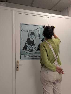 Photographie d'une artiste en train de réaliser la fresque de la lingerie